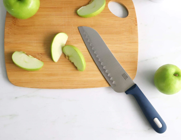 knife on cutting board with apples
