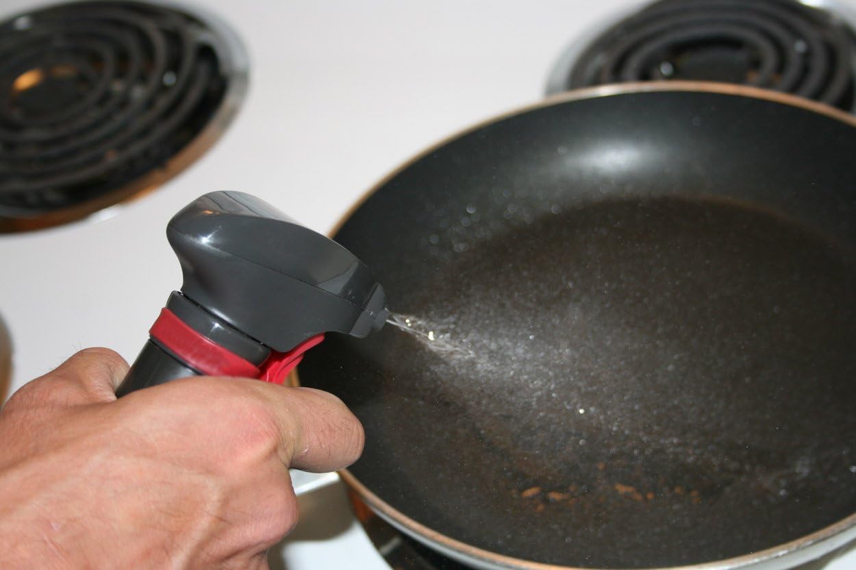 Person pouring oil into a hot frying pan on a stovetop