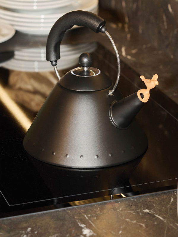 Black kettle on a stove with a blurred background