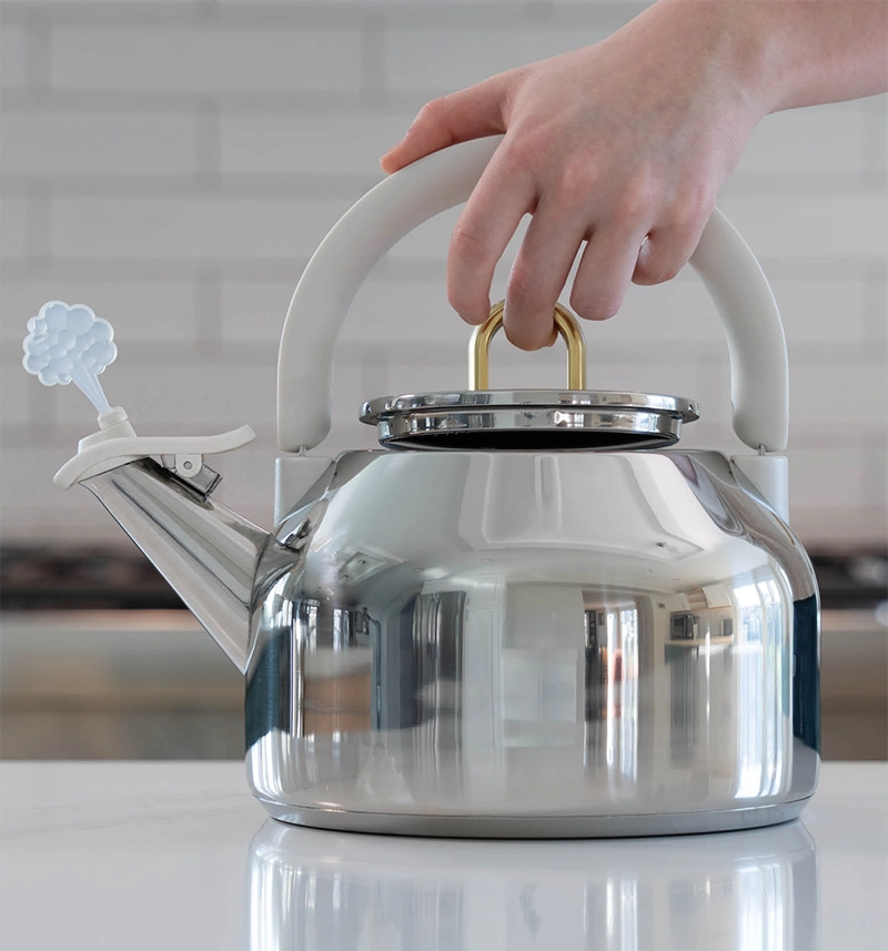 person using easy lift lid with their middle finger holding a tea kettle