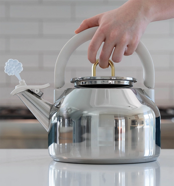 person using easy lift lid with their middle finger holding a tea kettle