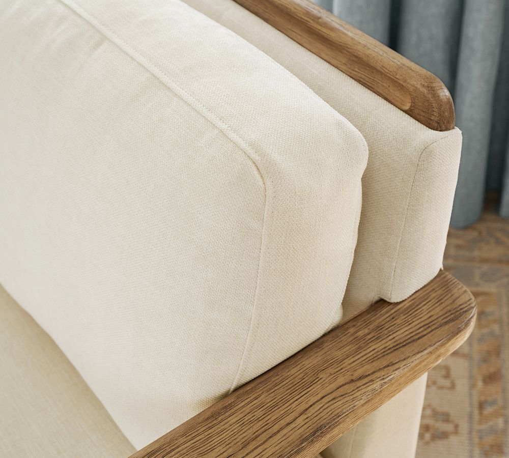 Close-up of a beige cushion on a wooden chair with a blurred background