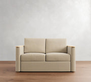 Beige sofa on a wooden floor with a plain white wall background