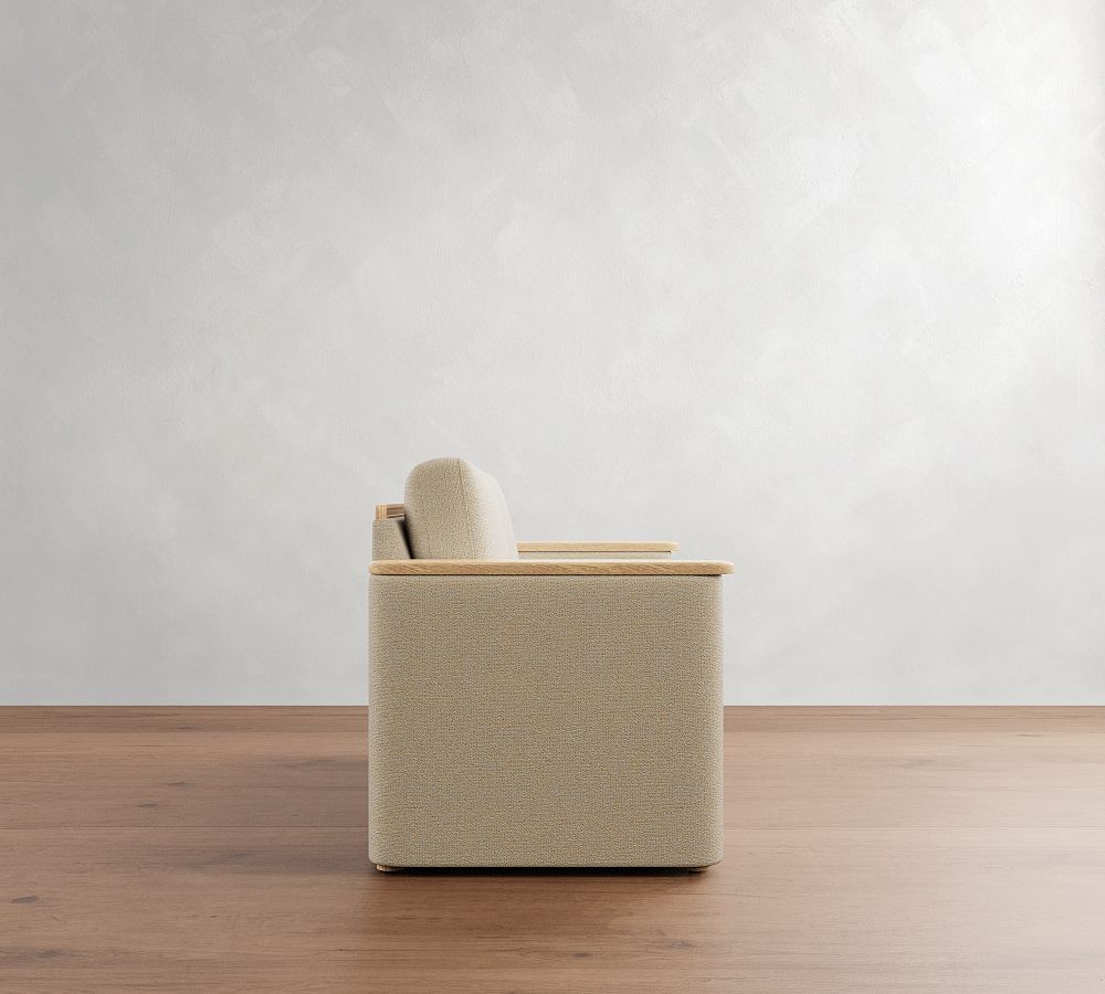Beige armchair on a wooden floor with a white wall background