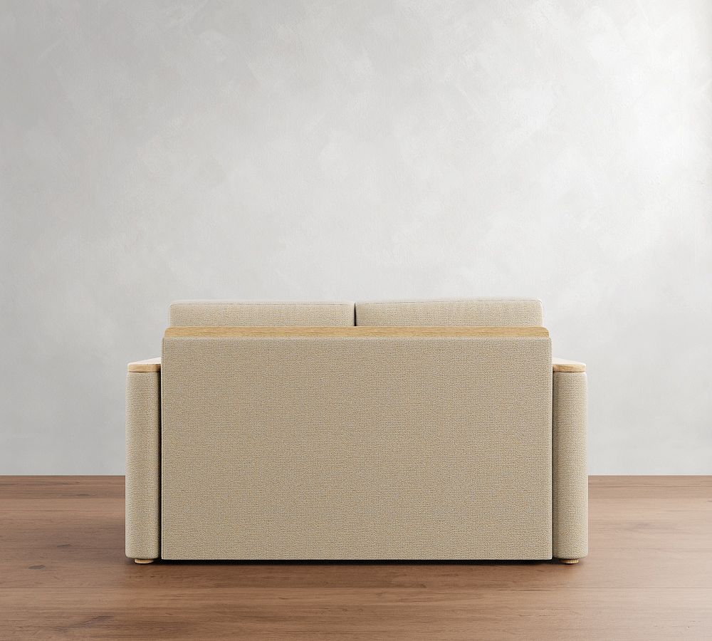 Beige sectional sofa on a wooden floor with a plain white wall background