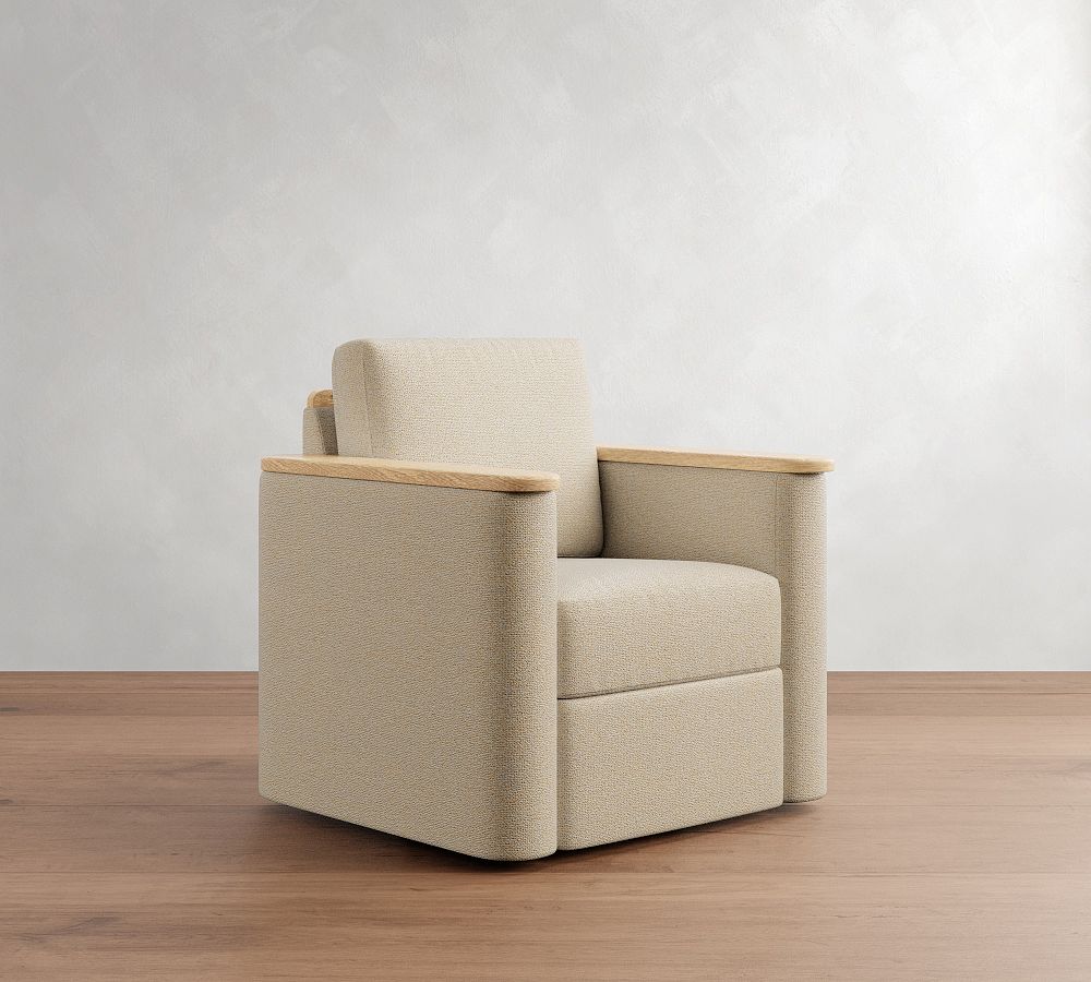 Beige armchair with wooden armrests on a wooden floor against a white wall