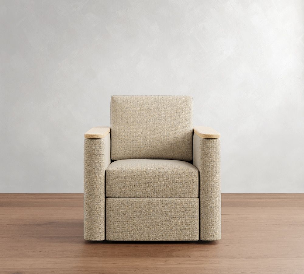 Beige armchair with wooden armrests on a wooden floor against a white wall