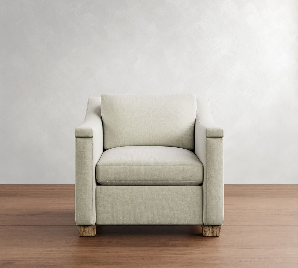 Beige armchair on a wooden floor with a white wall background