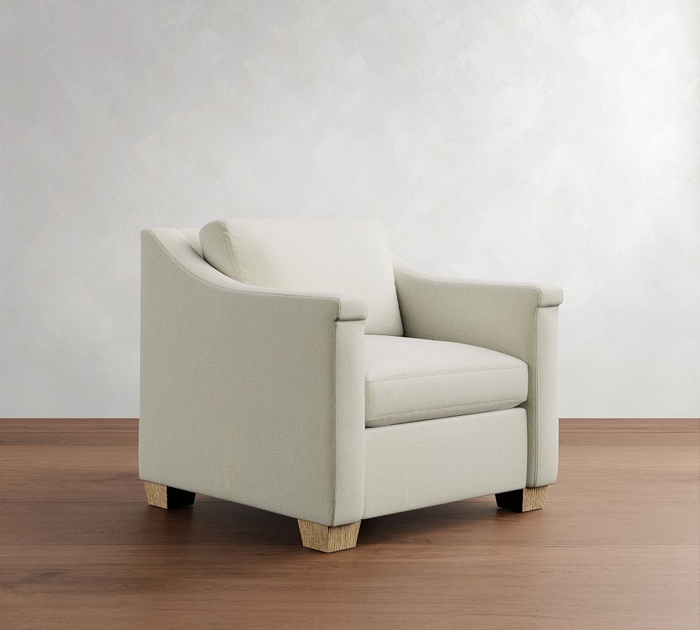 Beige armchair on a wooden floor with a white wall background