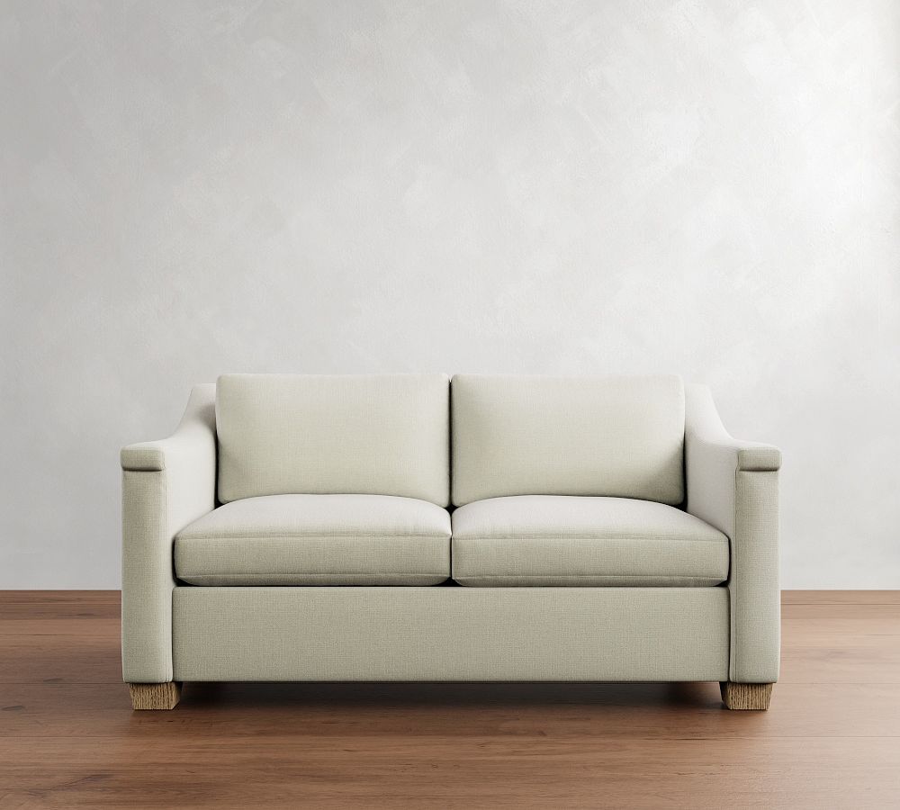 Beige sofa on a wooden floor with a white wall background