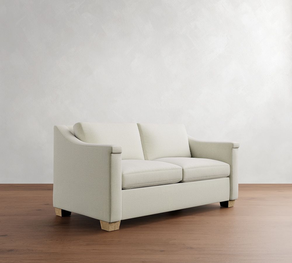 Beige sofa on a wooden floor with a plain white wall background